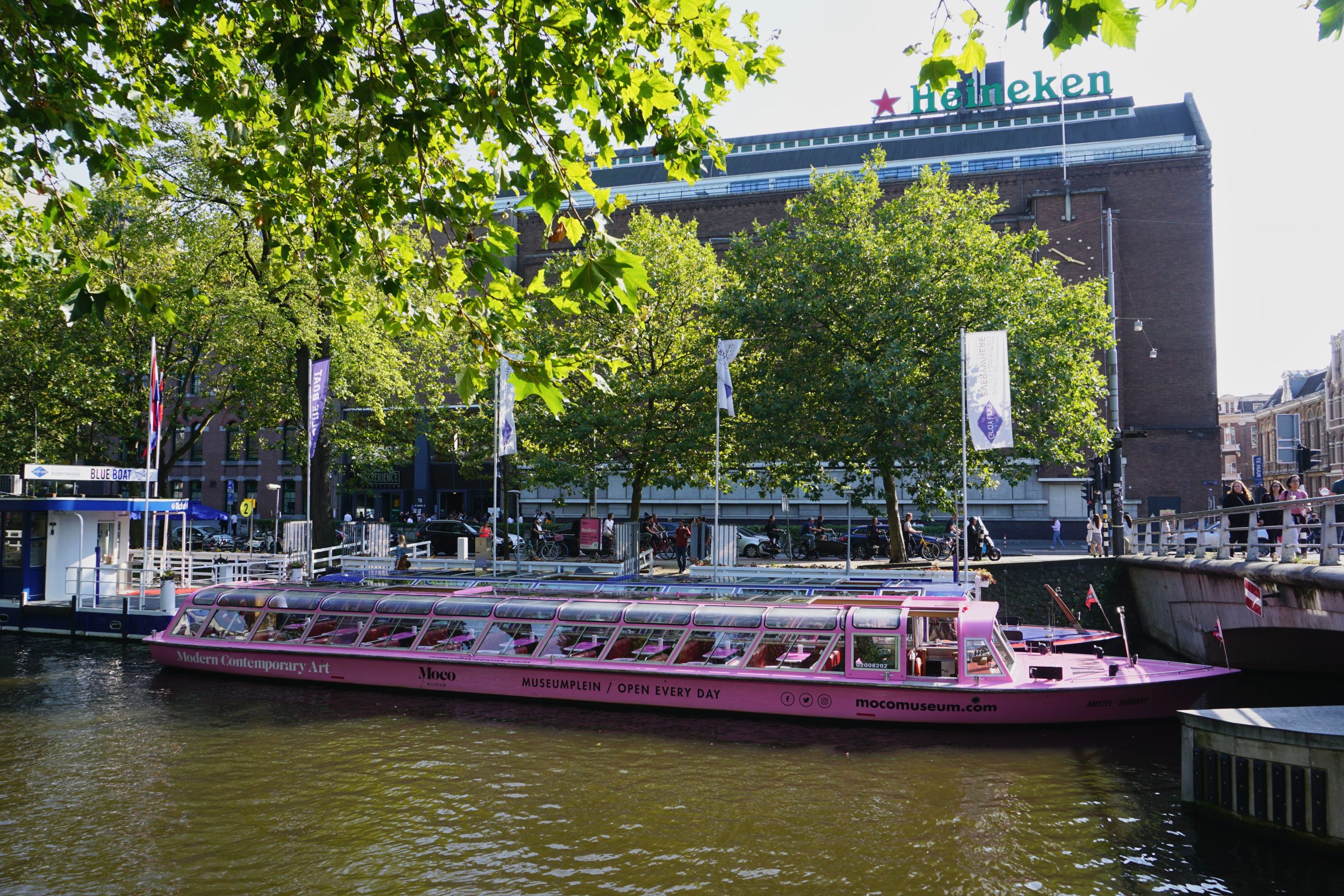Heineken Experience Amsterdam von außen mit einem Grachtenschiff davor